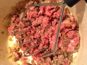 Add meat. A potato masher is one of the easiest ways to break up ground meats.